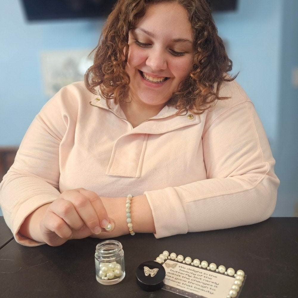 woman putting bead in jar for goal system